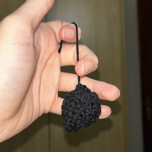 hand holding a not so round crochet ball